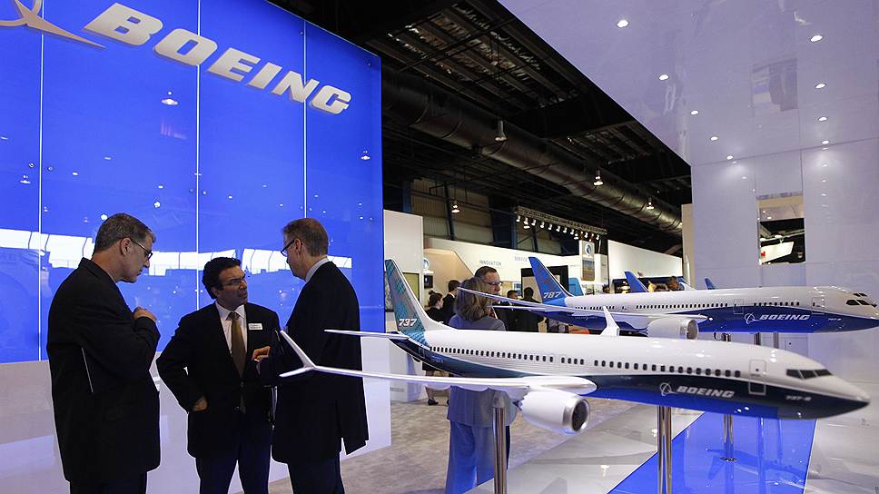 Посетители возле стенда Boeing обсуждают Singapore Airshow 2014