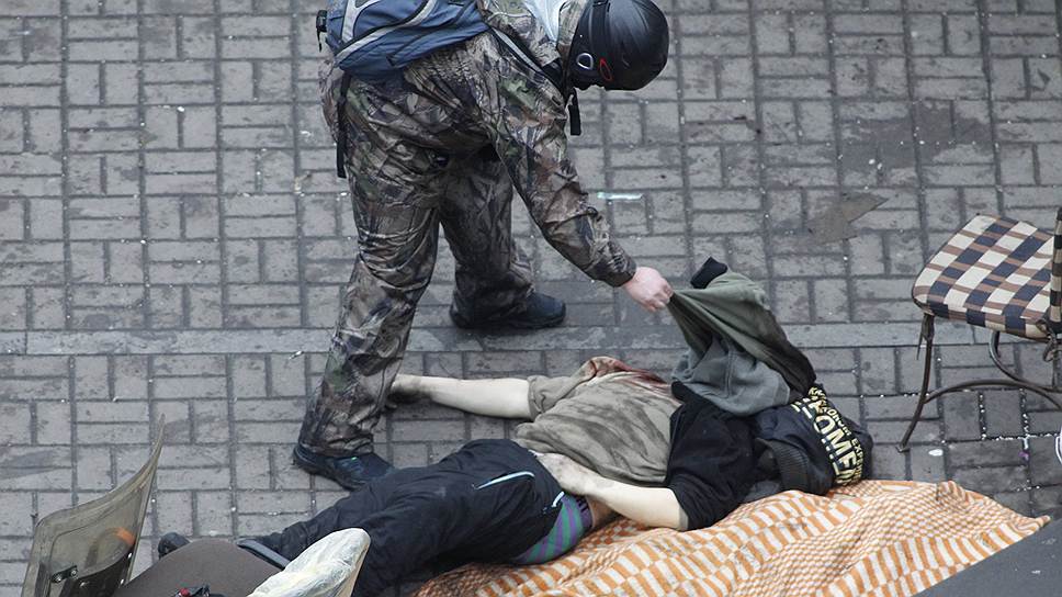 Тела убитых протестующих уносят из эпицентра событий во время противостояния с милицией на Майдане 20 февраля