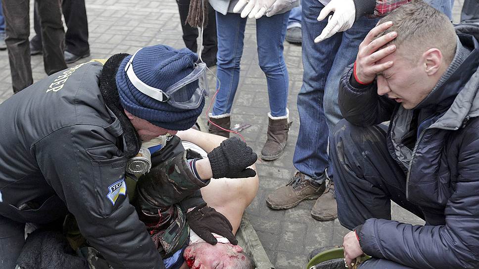 Тела убитых протестующих уносят из эпицентра событий во время противостояния с милицией на Майдане 20 февраля