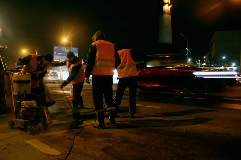 Рабочие выполняют ремонтные работы на автомобильной дороге
