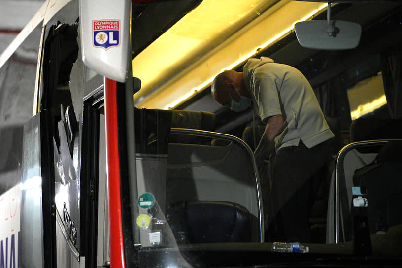 Полицейский берет отпечатки пальцев в автобусе, на котором перемещались лионские футболисты