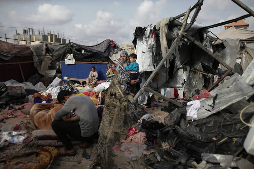 Палестинцы осматривают свои палатки, разрушенные в результате бомбардировки