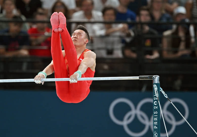 Китайский гимнаст выполняет программу на перекладине