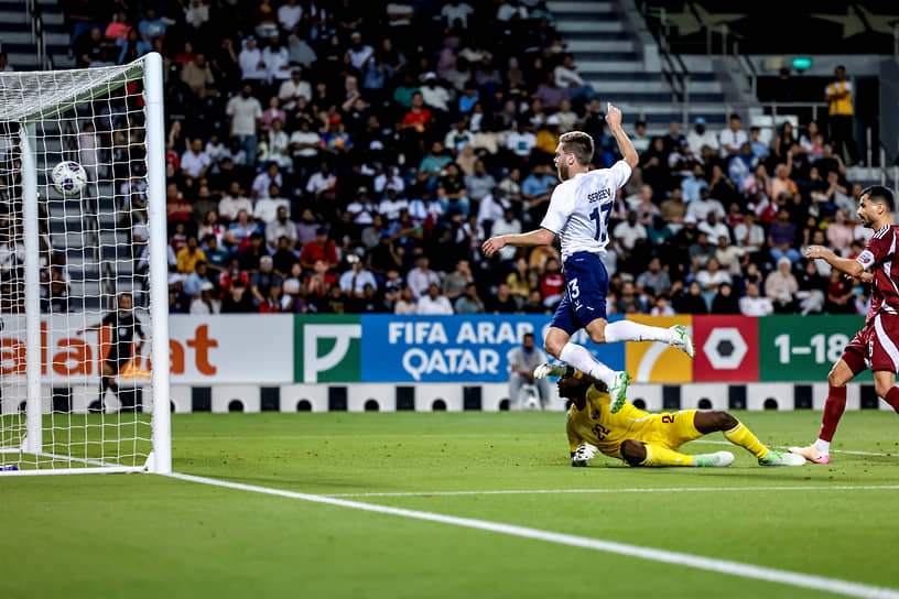 Игрок сборной России Иван Сергеев (в центре) забивает гол в ворота Катара