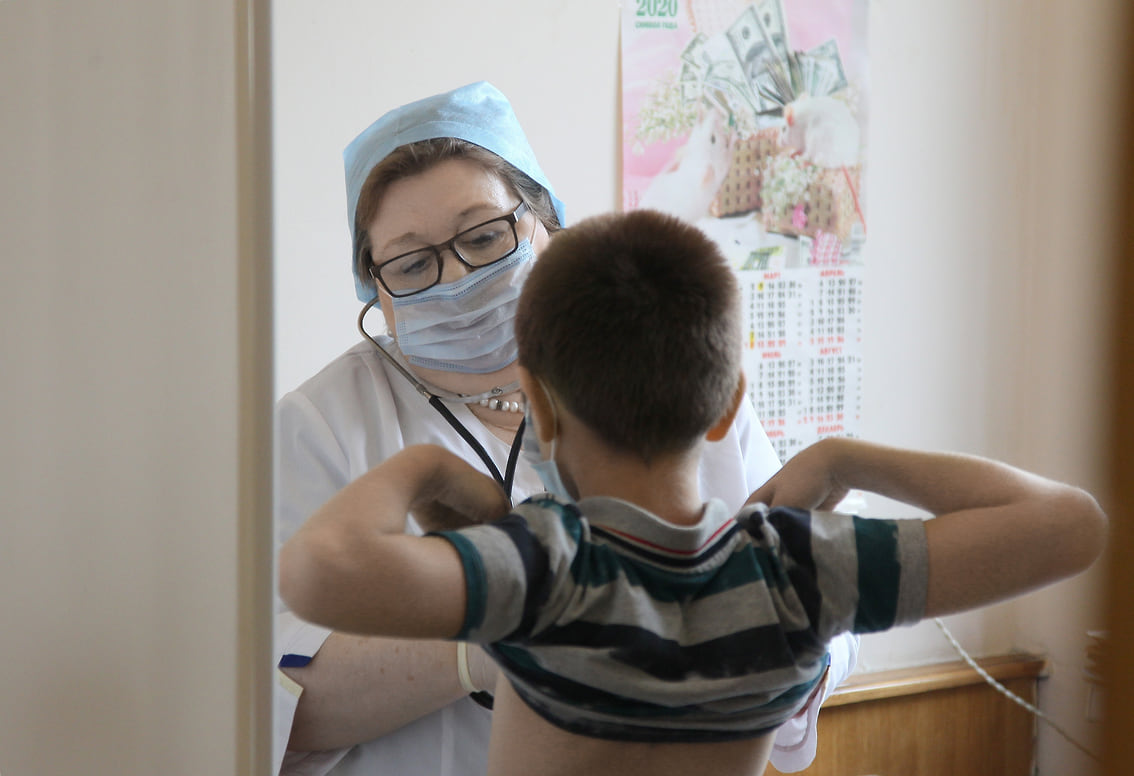 A medical professional attending to a child in a clinic setting.