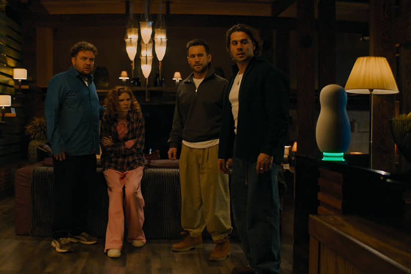 Голосовой помощник, похожий на одноглазую матрешку, предлагает сыграть в игру, а когда герои отказываются, отключает сотовую связь, блокирует двери и запускает снотворный газ