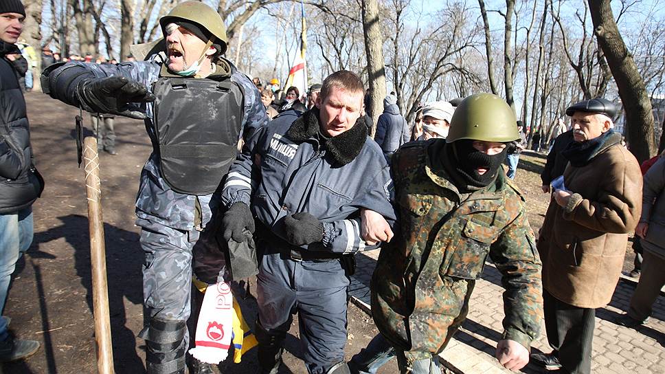 Евромайдан. Противостояние на улице Институтской. Бойцы Самообороны выводят раненого милиционера.

