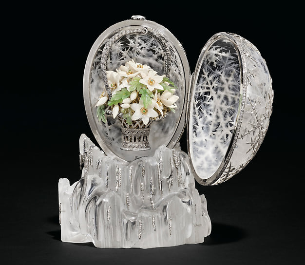 Яйцо раскрывается, открывая платиновую корзинку с двойной решетчатой ручкой, украшенную бриллиантами розовой огранки, наполненную искусно вырезанными анемонами из белого кварца и дерева, каждый из которых украшен золотой проволочной ножкой и тычинками