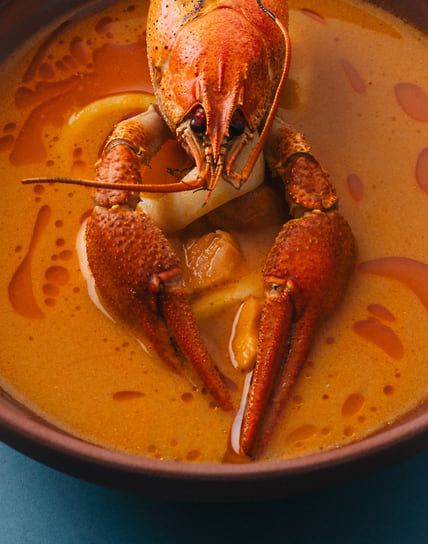 Биск с раком, масляной рыбой, форелью и кальмаром