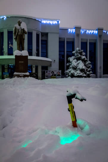 Занесенный снегом памятник Ленину у здания вокзала