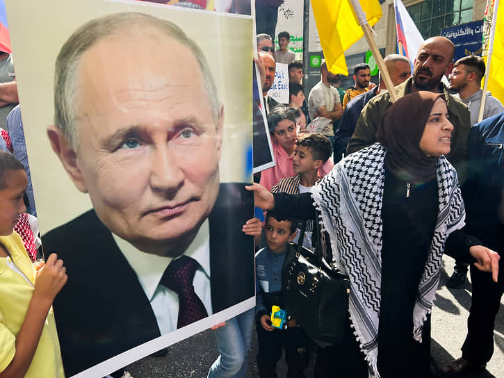 Люди держат фотографию президента России Владимира Путина во время акции в поддержку Газы, Хеброн, Западный берег Иордана