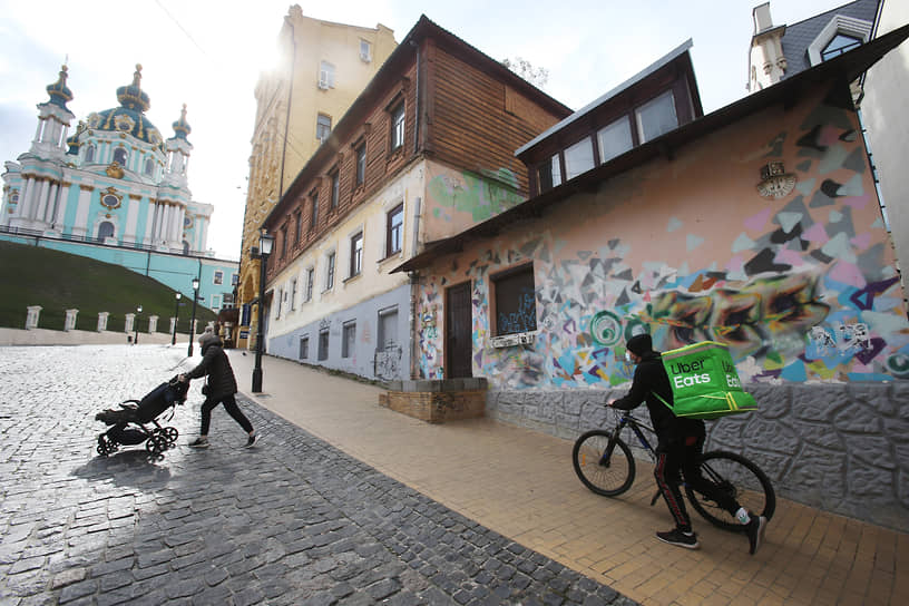 Курьер службы доставки еды едет по улице Киева