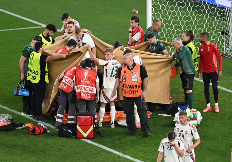 Медики оказывают помощь венгерскому футболисту Барнабашу Варга после столкновения
