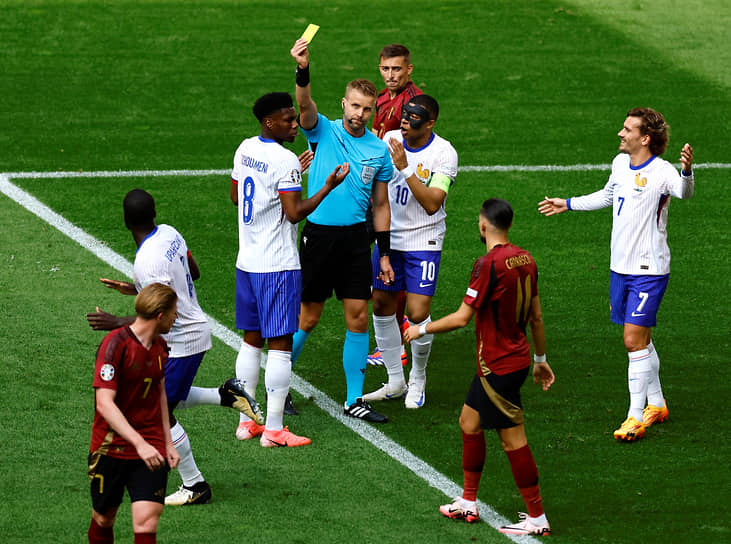 Рефери показывает игроку сборной Франции Орельену Чуамени желтую карточку