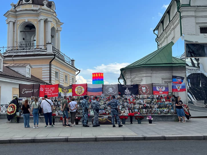 Участники акции, прохожие и сотрудники ОМОН у стихийного мемориала ЧВК «Вагнер»