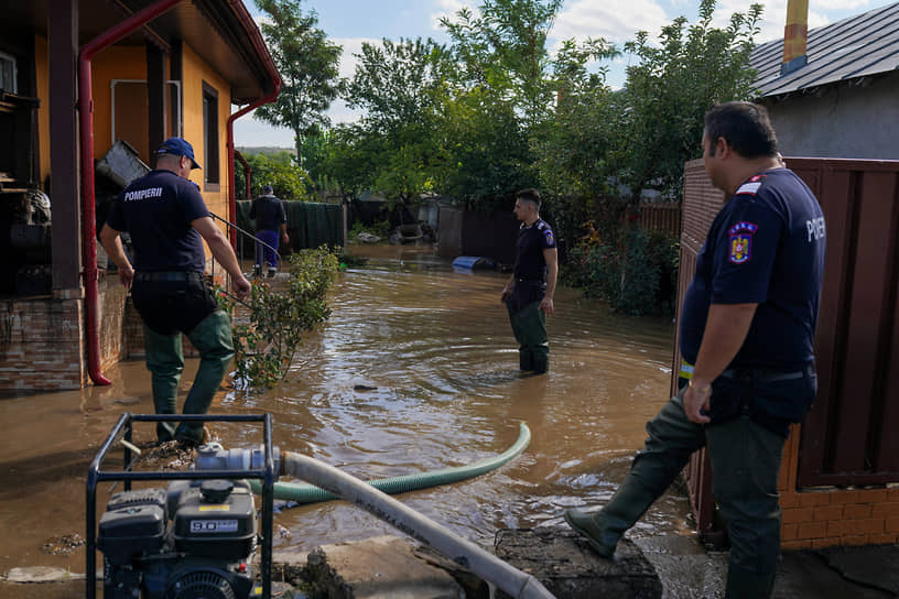 Пожарные откачивают воду из затопленного дома в коммуне Пече (Румыния)