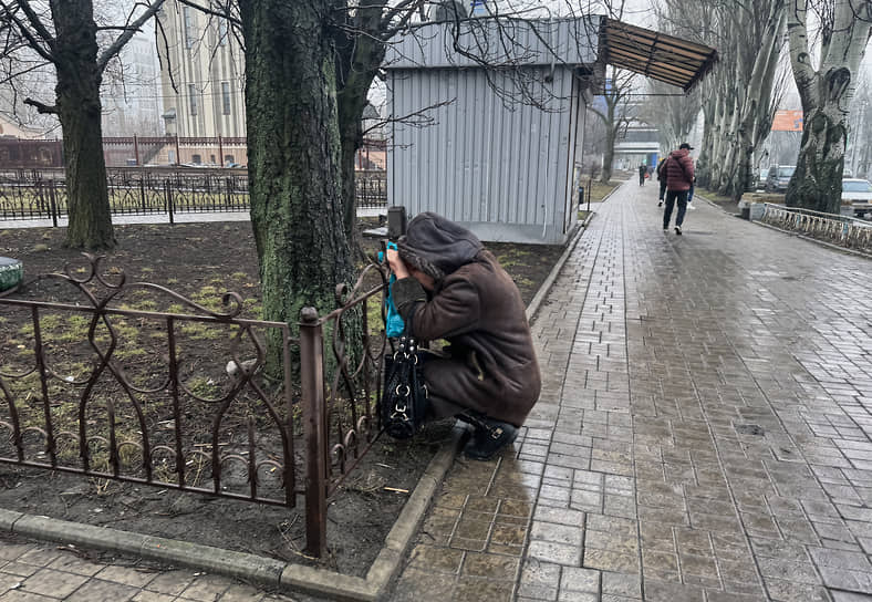 Женщина рядом с местом обстрела в Киевском районе Донецка