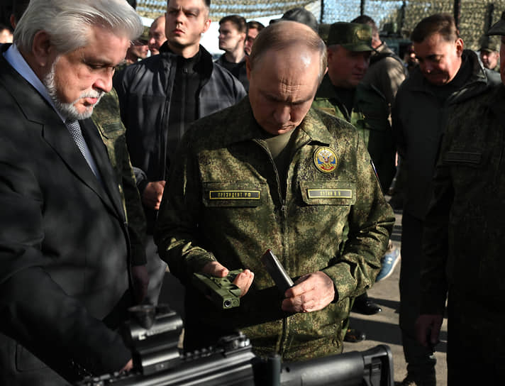 Президент России Владимир Путин (в центре) и генеральный конструктор по носимому вооружению и экипировке военнослужащих АО «Концерн &#39;&#39;Калашников&#39;&#39;» Владимир Лепин (слева) во время осмотра вооружения, военной и специальной техники на территории военного полигона «Мулино»