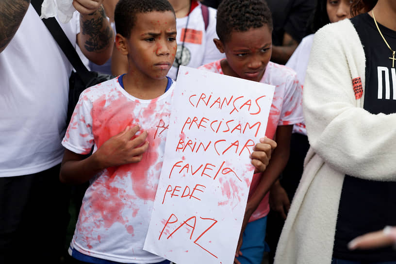 Надпись на плакате: «Детям нужно играть, фавела просит мира»