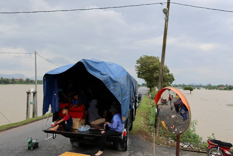 Семья укрывается в кузове грузовика, поскольку их дом затапливает вода после сильного дождя в северных штатах Малайзии