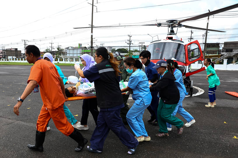 Медики несут на носилках пострадавшего при наводнении в Таиланде