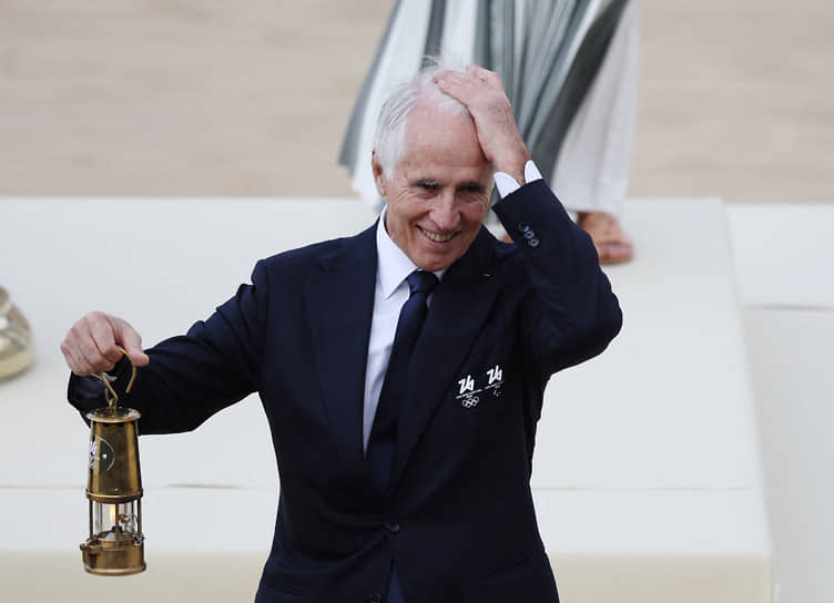 Глава оргкомитета Игр Джованни Малаго держит сосуд с олимпийским огнем