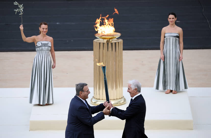 Джованни Малаго и Исидорос Кувелос держат факел с олимпийским огнем