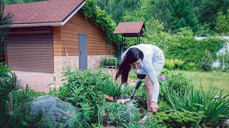 Женщина любит ухаживать за растениями на приусадебном участке