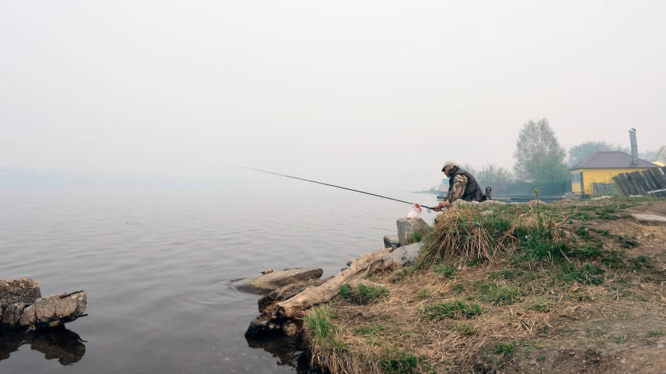 Рыбак во время ловли рыбы на берегу реки в Режевском городском округе, где из-за пожаров объявлен режим чрезвычайной ситуации