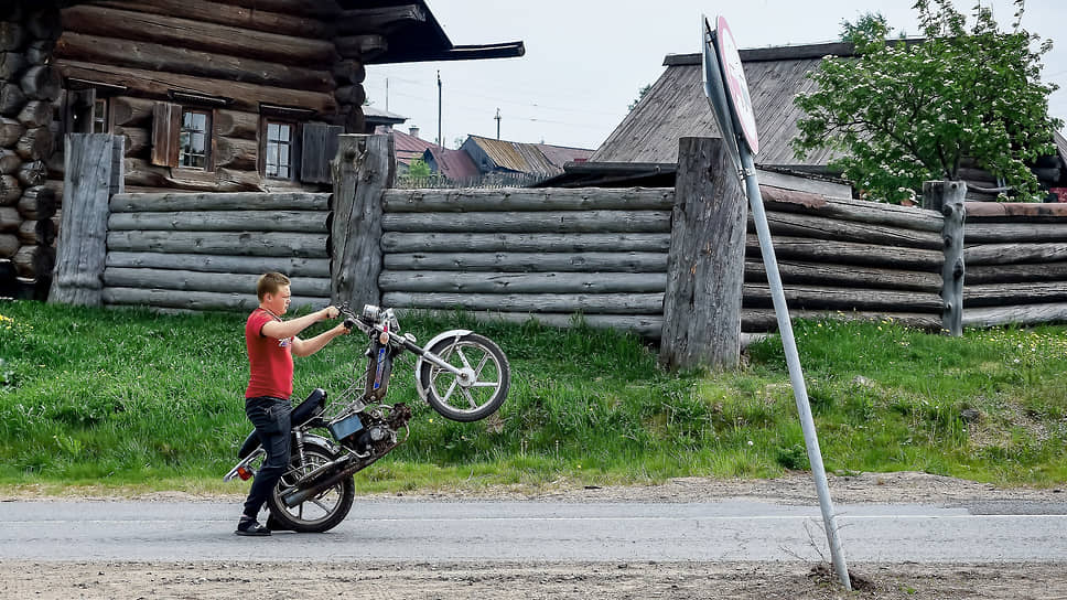 Житель села Нижняя Синячиха Алапаевского района Свердловской области с мопедом на сельской улице