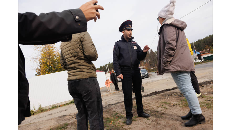 Акция протеста жителей микрорайона Уктус против передачи здания бывшего профилактория, находящегося вблизи жилых домов и школы, ГУФСИН для размещения в нем исправительного центра для заключенных в Екатеринбурге. Сотрудник полиции предупреждает местную жительницу о возможности её задержания