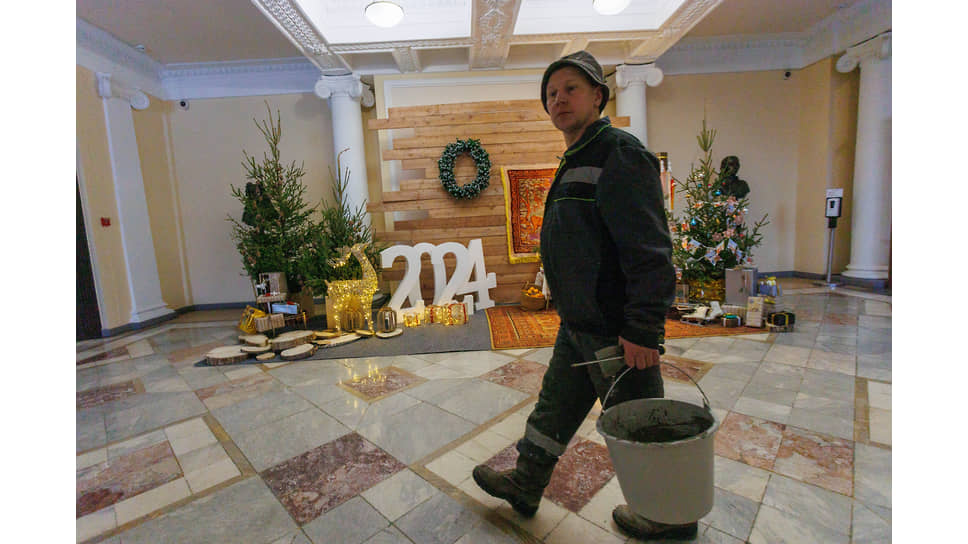 Сотрудник строительной фирмы проходит около новогодней  фотозоны в здании администрации Екатеринбурга