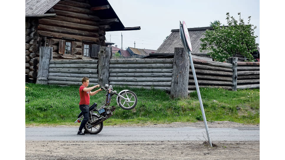 Житель села Нижняя Синячиха Алапаевского района Свердловской области с мопедом на сельской улице