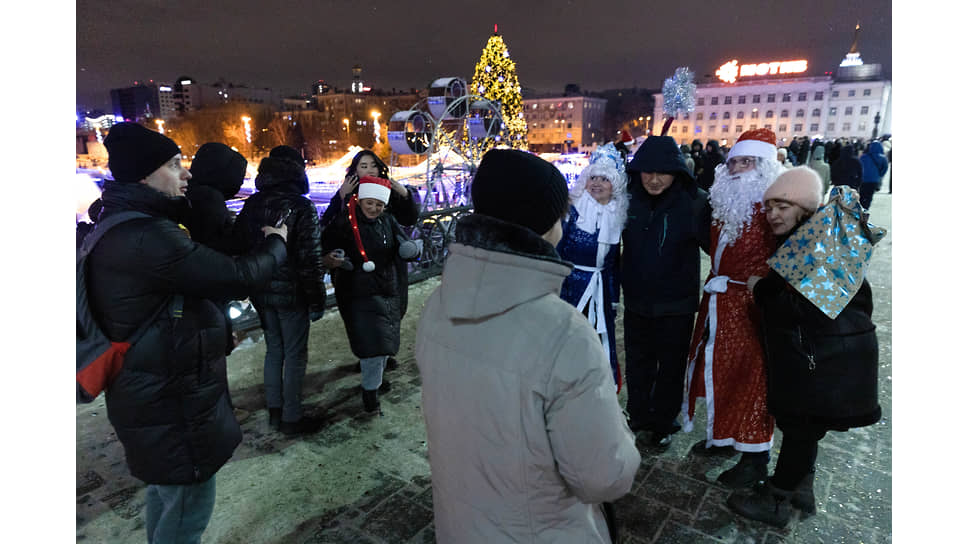 Артисты в костюмах Деда Мороза и Снегурочки на улице города
