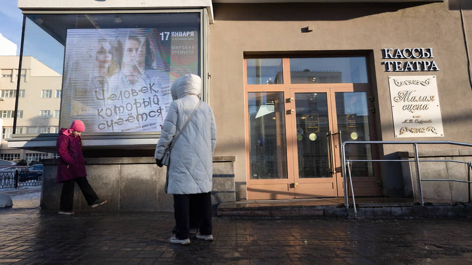 Люди у афиши спектакля "Человек, который смеется" на здания Свердловского театра музыкальной комедии
