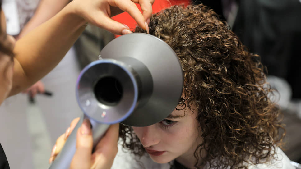 Модель во время процедуры завивки волос