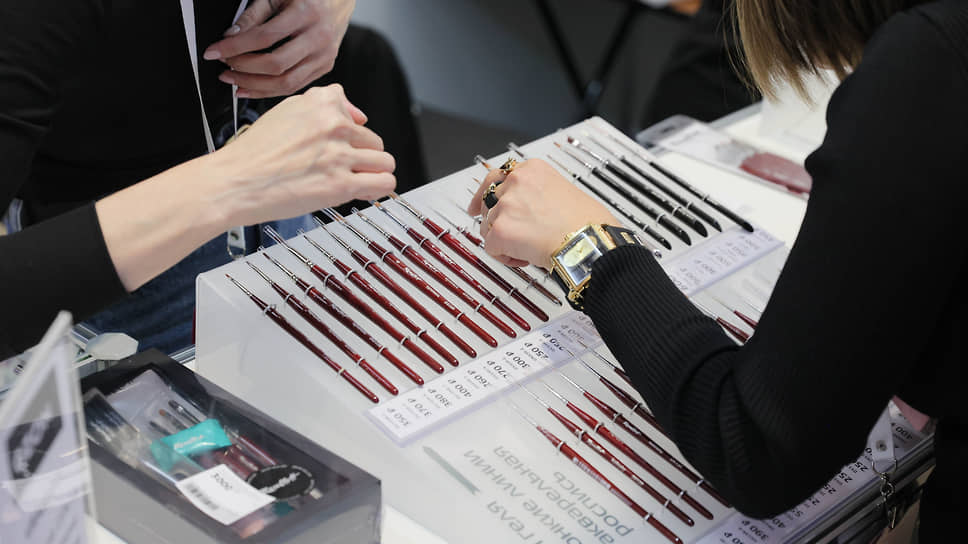 Выставка Beauty Expo Ural в Ельцин-центре. Посетитель у стенда с кистями для маникюра