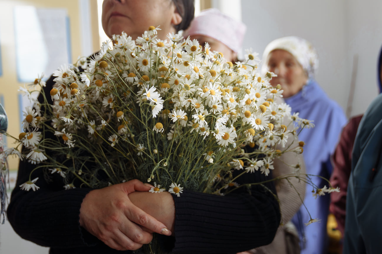 Женщина с букетом ромашек на прощании с Екатериной Шкляевой