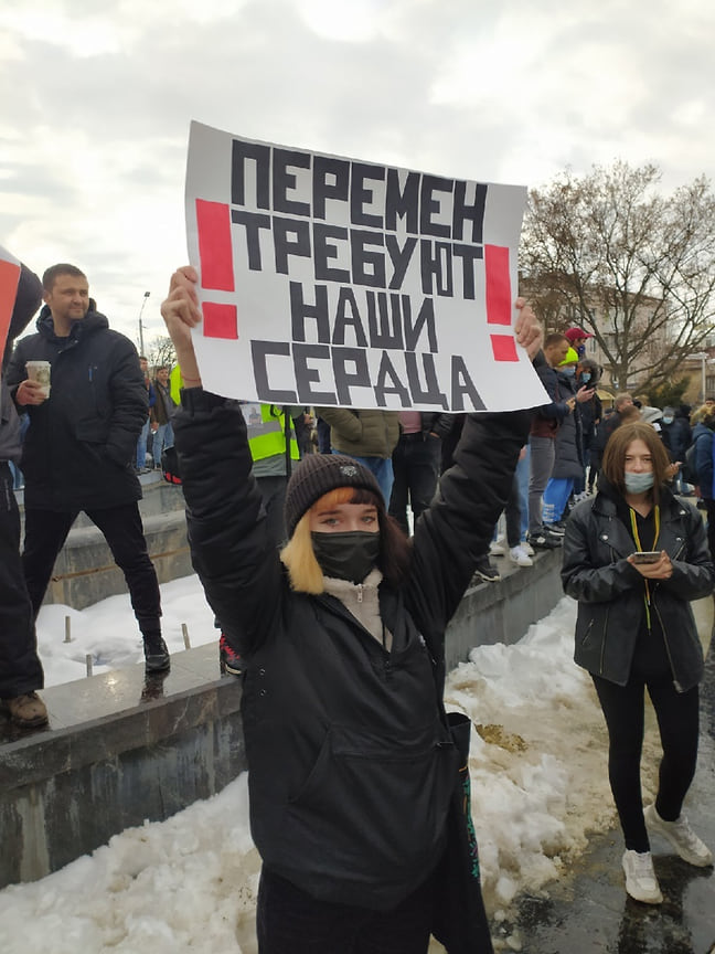 Девушка с плакатом «Перемен требуют наши сердца»