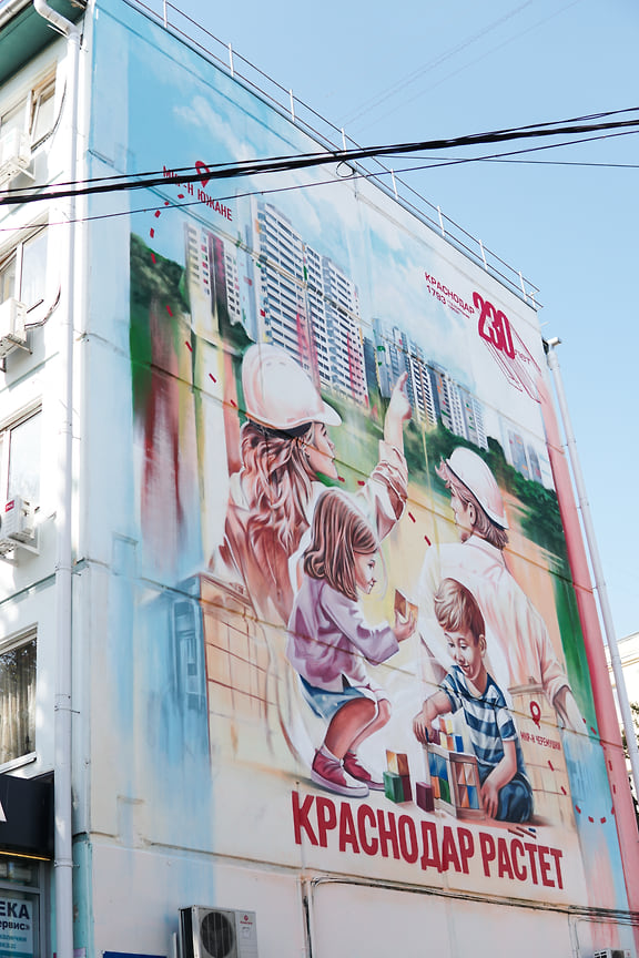 На улице Ставропольская, 129 торжественно открыли граффити с поздравительной открыткой, иллюстрирующей изменения в городском облике за последние десятилетия