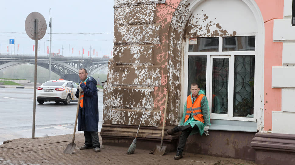 Сотрудники ЖКХ очищают от грязи стену здания в Нижнем Новгороде