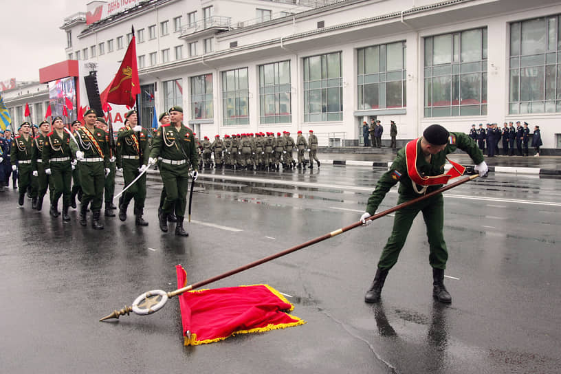 9 мая, Нижний Новгород. Участник парада в честь Дня Победы пытается поднять упавший штандарт Карельского фронта