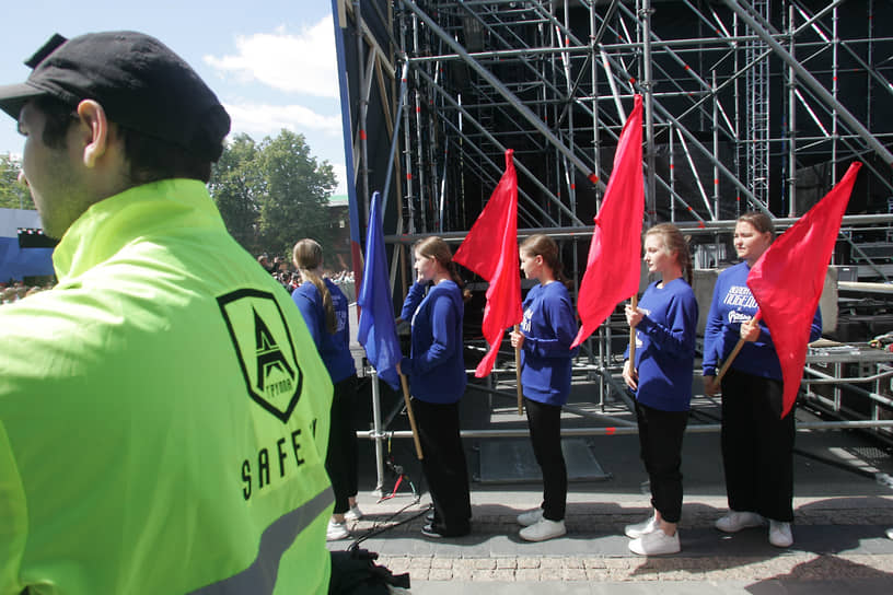 Колонна волонтеров со знаменами за спиной охранника