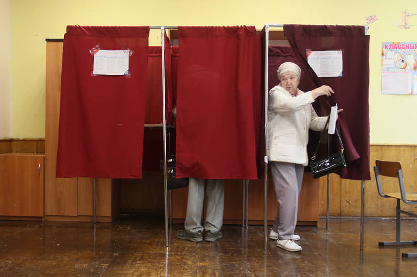 Пенсионерка выходит из кабинки для голосования на избирательном участке в здании школы №30