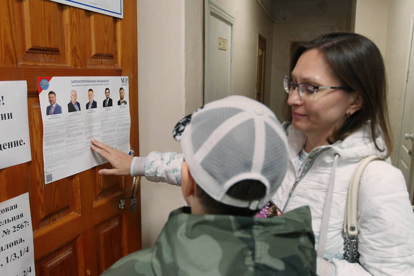 Женщина с сыном изучают список кандидатов