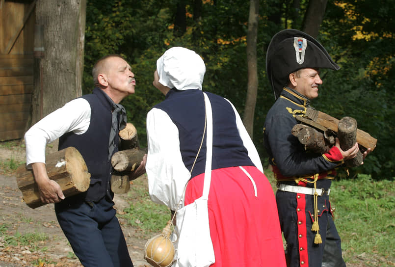 Участники команды эпохи Наполеона несут дрова для костра