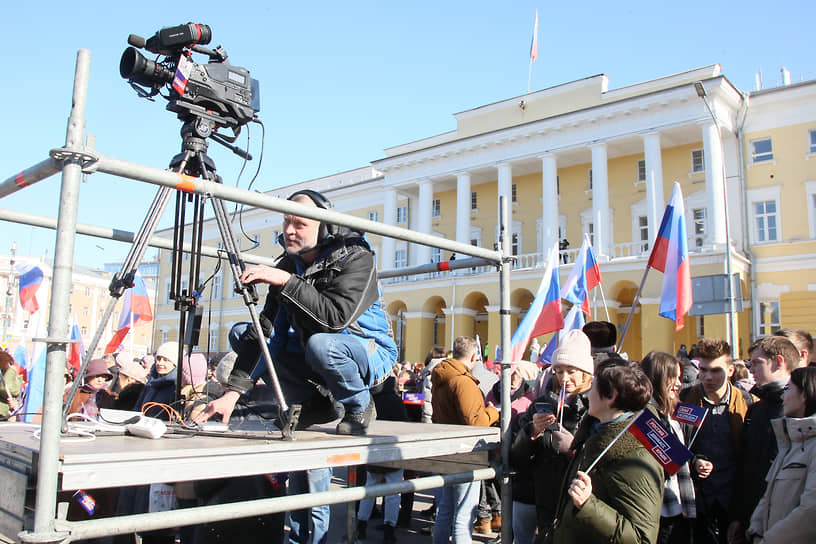 Телеоператор Роман Кипарин настраивает камеру для прямой трансляции митинга в честь присоединения Крыма
