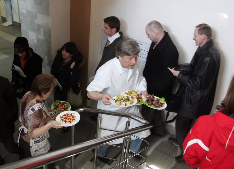 Официанты несут тарелки с закусками для участников совещания