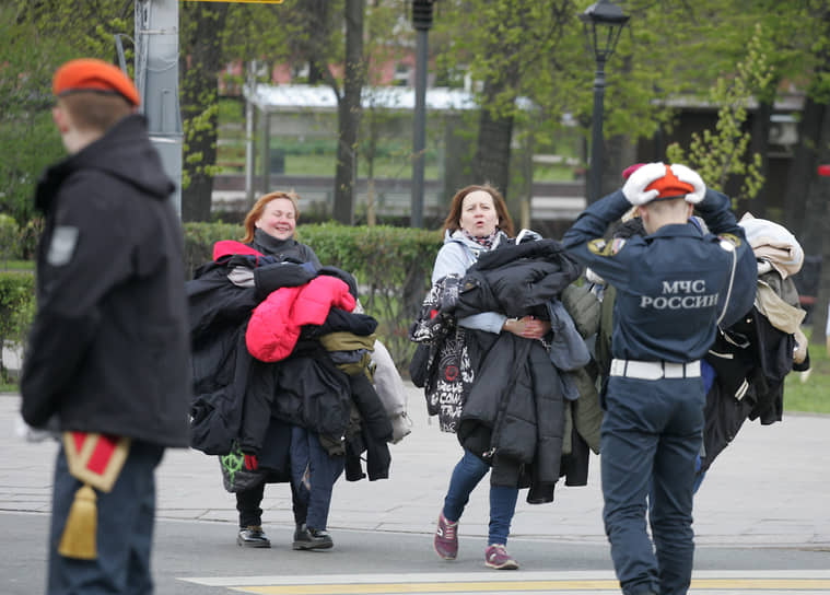Женщины несут верхнюю одежду кадетам после репетиции парада Победы
