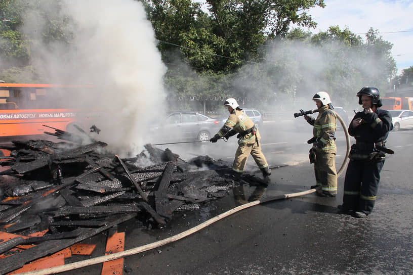 Пожарные тушат дрова, сваленные на проезжую часть горящим мусоровозом